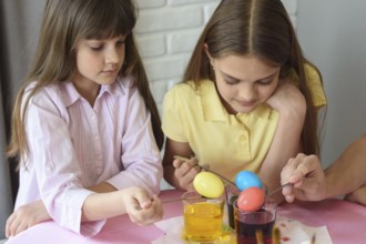 Children stain eggs in a special dye in glasses
