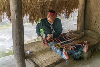 Old woman sew in traditional tribal dress