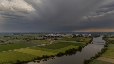Fields and river stretch out under threatening dark clouds at sunset, Bogen, Lower Bavaria