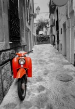 Mediterranean street with old retro red scooter in Palma de Mallorca Spain