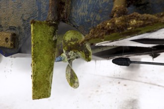 Boat stern hull and propeller pressure water cleaning on beached ship