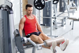 Man lifting weights with a leg press on sport gym club