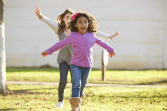 Multi ethnic kid girls playing running in park outdoor