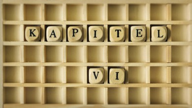 An image of a wooden game with the word chapter six in german language