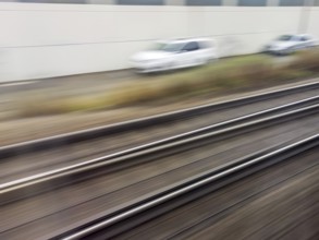 Tracks and rails in motion from a moving train. Symbolic photo for train journey, speed and