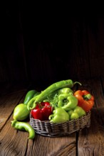 Various harvested peppers and hot peppers in basket