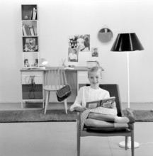 In the 1960s. A teenage girl in her typical 1960s room, a desk and her things with pictures of her