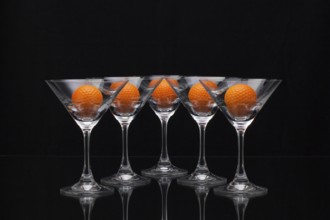 Five glasses of champagne with golf balls
