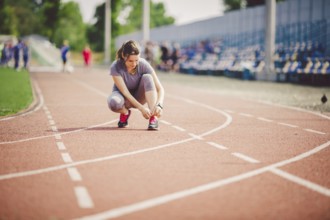 Theme sports and sportswear. A young Caucasian woman in uniform lacing shoelaces adjusting shoes