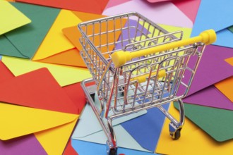 Shopping trolley and different colored envelopes on the table