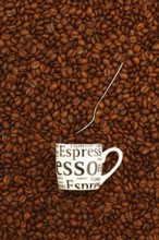 Cup of coffee on a table full of coffee beans. Coffee design
