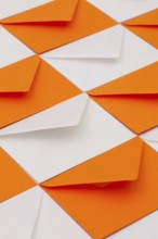Composition with white and orange envelopes on the table