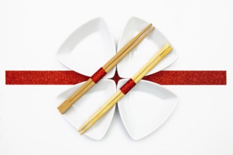 Ceramic bowls and bamboo chopsticks for sushi food with red and white decoration