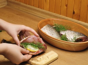 Fish carcass with spices on wooden hardboard, prepared for cooking