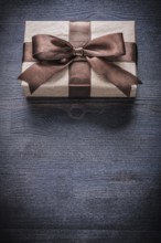 Gift box-container in wrapping paper on vintage wooden board