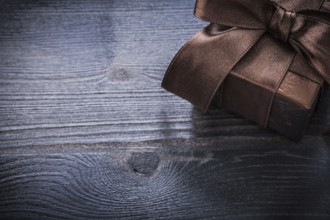 Wrapped present box shining paper on wood board holiday concept