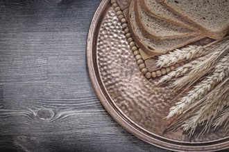 Golden rye wheat ears slices of brown bread vintage brass tray food and drink concept