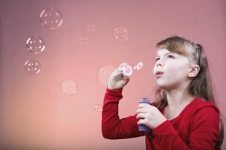 A little girl blowing soap bubbles