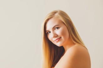 Portrait of a beautiful blonde woman with bare shoulders and back wearing natural make-up against