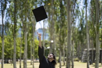 Graduated man throwing graduation hat in the air