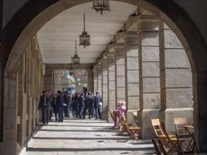 Group of businessmen under the colonnade of Cervantes Square, Santiago de Compostela, Galicia,