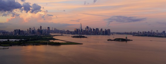 Three cities can be seen in this view of Hudson Bay at dusk with the Statue of Liberty Visable