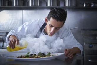 Chef working in kitchen with smoke and oil at restaurant