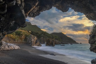 Silhouette frame of a beach cave and view Marina di Maratea Beach at sunset