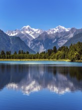 The forests and Mount Cook and Mount Tasman. Magnificent snow-capped mountains surround the smooth,
