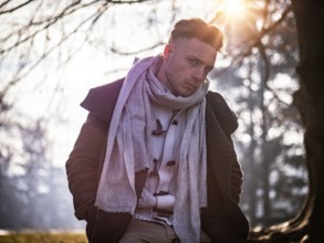 One handsome blue eyed young man in urban setting in European city park