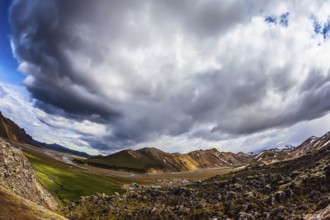 Travel to Iceland in July, volcanic summer tundra. Multi-colored rhyolite mountains - orange,