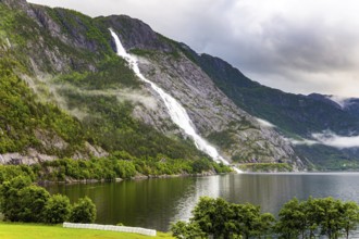 Magnificent giant picturesque Langfossen waterfall and flows into the Acre Fjord. Majestic natural