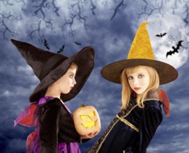 Halloween kid girls and pumpkin on cloudy moon sky