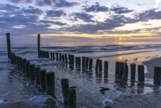 Beautiful Sunset at the seaside in the Netherlands with strong colours in the clouds and the water