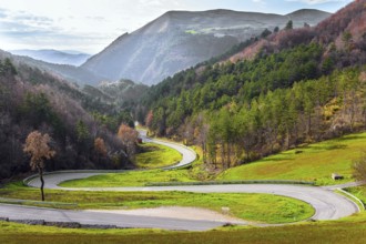 Winding mountain road serpentine after the rain. Wet asphalt. Cloudy winter day. Italy. Magnificent
