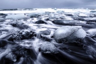 Dramatic seascape with floating blocks of ice and wild waves, Diamond Beach, Iceland, Europe