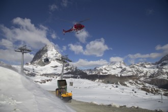 Zermatt, Switzerland, April 13, 2017: A helicopter loading concrete at a construction site in the