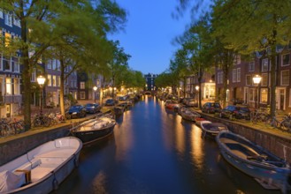 Night view of buildings and boats along the canal in Amsterdam, Netherlands