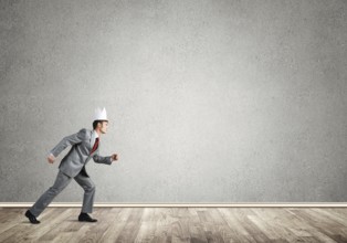 Young handsome businessman wearing white paper crown running in a hurry