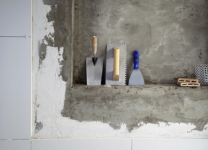 Construction stainless steel trowel tools and spatula on cement mortar wall
