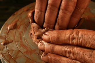 Pottery craftmanship red clay potter hands work finger closeup