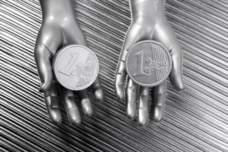 Two silver euro coins in futuristic robot gray metallic hands bank metaphor