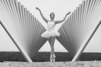Black and white photograph of a ballerina in front of a modern sculpture, Emmendingen,