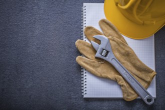 Notebook hard hat adjustable wrench protective gloves construction concept