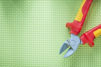 Sharp insulation nippers on green background electricity concept