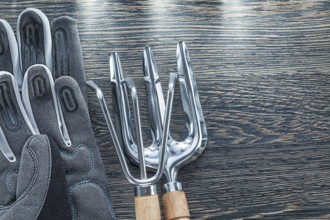 Gardening rake trowel fork protective gloves on wooden board