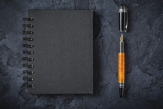 Black Notepad And Fountain Pen On Black Background