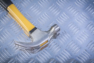 Claw hammer on corrugated metal background construction concept
