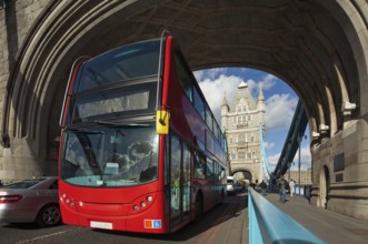 The famous Tower Bridge in London, UK. Double-decker bus passes under the arch of the tower. Sunny