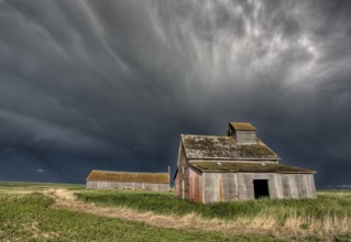 Abandoned Farm with storm clouds in the Canadian Prairie